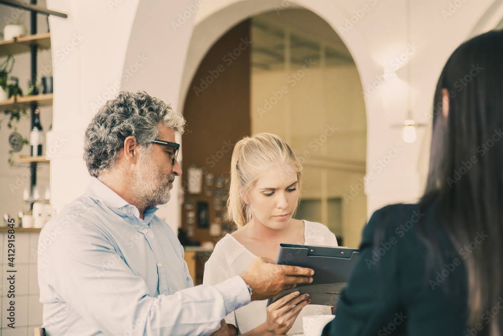 Young and mature customers meeting with agent and signing insurance agreement. Business meeting concept Young and mature customers meeting with agent and signing insurance agreement. Business meeting concept