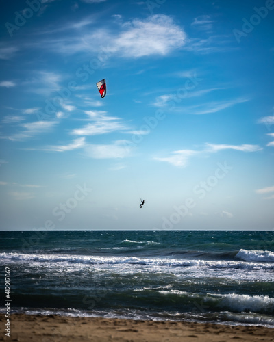 Windy beach with kite surfer jumping on the background