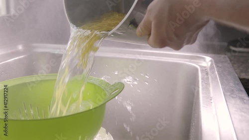 close up in slow motion, spelt noodles strain in colander. Vegetarian, vegan kitchen scene in UHD, 4K