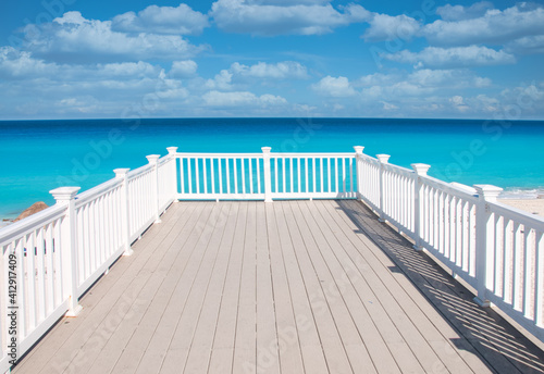 Panoramic view of the Caribbean Ocean with the clear turquoise water of the Mexican coast  from a white wooden terrace on the beach of Cancun