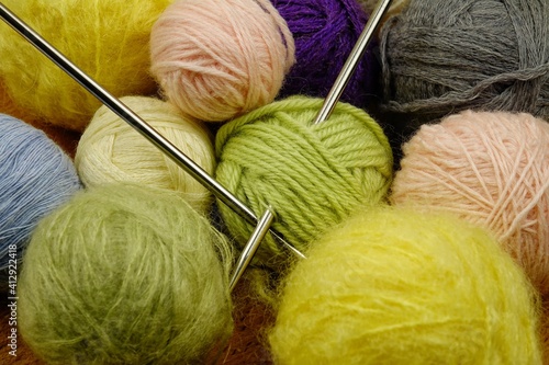 Balls of colored yarn for knitting on a dark wooden black background