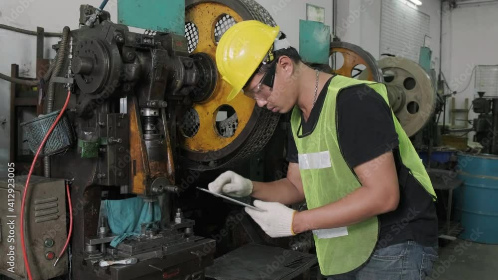 An Asian male engineer or worker inspects and repairs machines after use. industrial and engineering concept. An Asian male engineer or worker inspects and repairs machines after use. industrial and engineering concept.