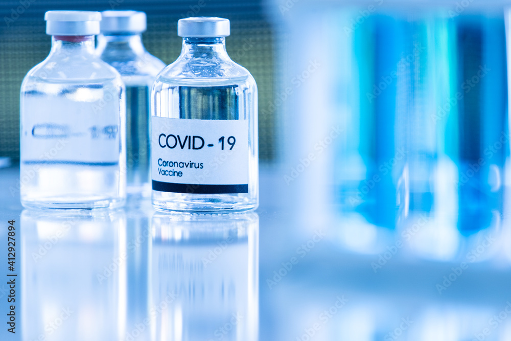 Bottle of COVOD-19 vaccine sample in a laboratory. Idea for researching and lab tests for coronavirus curing Bottle of COVOD-19 vaccine sample in a laboratory. Idea for researching and lab tests for coronavirus curing