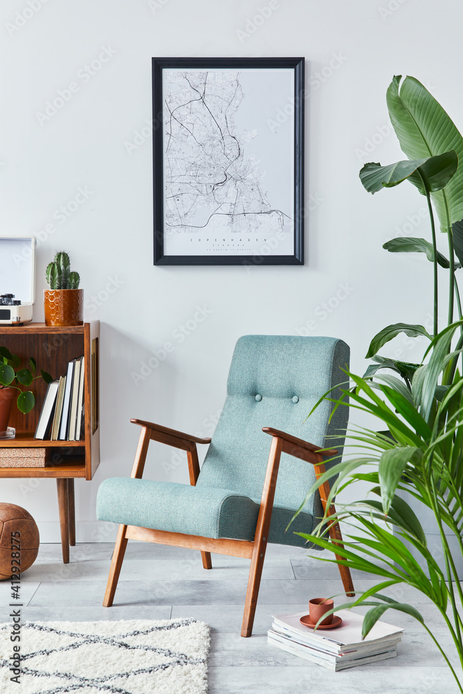 Fototapeta premium Stylish interior of living room with design wooden shelf, retro armchair, plants, mock up poster map, decoration, book, cacti and personal accessories in retro home decor. Template.