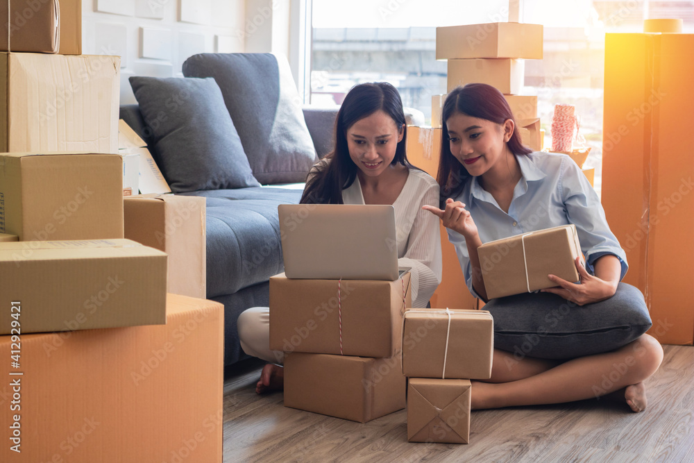 The young  Asia Businesswoman makes parcel.They are makes it for order online.they are happy and smiles.Gift , Business,work woman,Freelance,happy,pleasure.Photo concept work and Shopping.