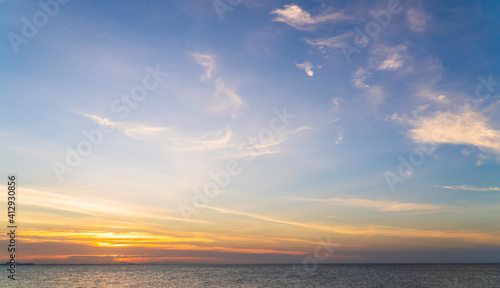 Sunset sky over sea in the evening with colorful orange sunlight cloud, Dusk sky background  © Nature Peaceful 