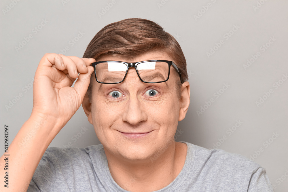 Portrait of happy mature man holding glasses on forehead and smiling Portrait of happy mature man holding glasses on forehead and smiling