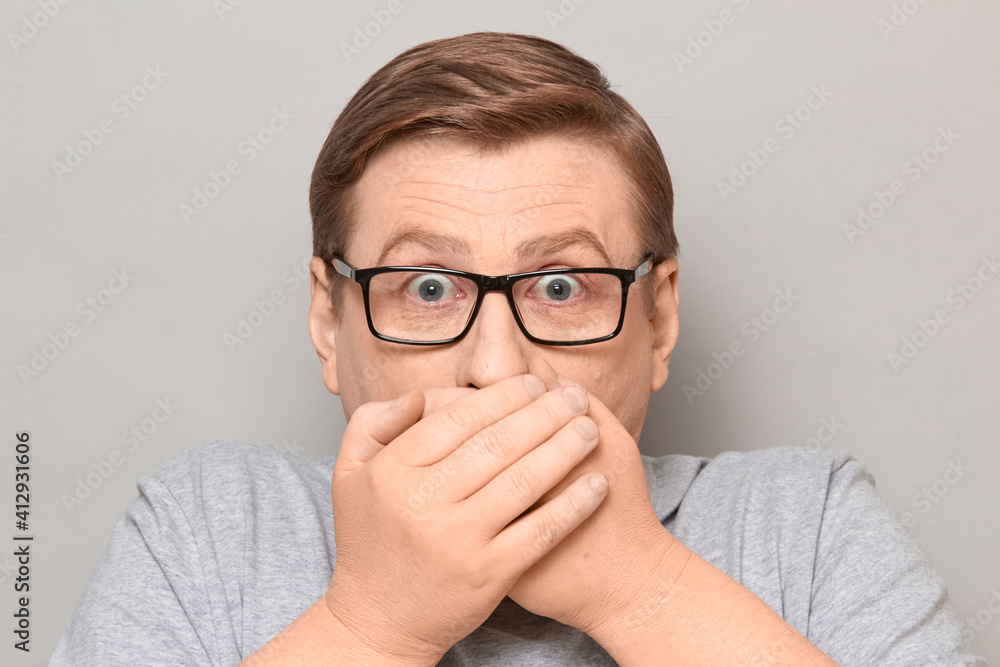 Portrait of shocked frightened man covering mouth with hands Portrait of shocked frightened man covering mouth with hands