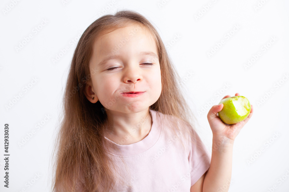 A sweet girl of European appearance with pleasure eats an apple. Proper nutrition. Child health. Vegetaridism A sweet girl of European appearance with pleasure eats an apple. Proper nutrition. Child health. Vegetaridism