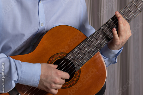man is holding a guitar. Preparing to play a musical instrument
