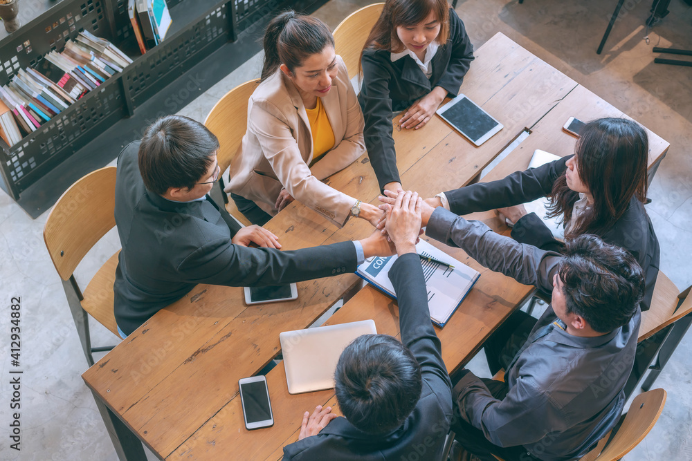 Fototapeta premium Top view group of peoples joining hands for starting business project.