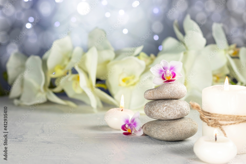 Spa resort therapy composition. Stones, burning candles, towel, abstract lights