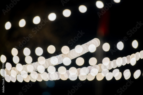 Golden light bulbs on the night dark background. Bokeh soft abstract background. Bokeh - Image