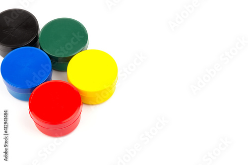 Closed plastic jars with paint of different colors for children's creativity on white background. Paint bottles for art
