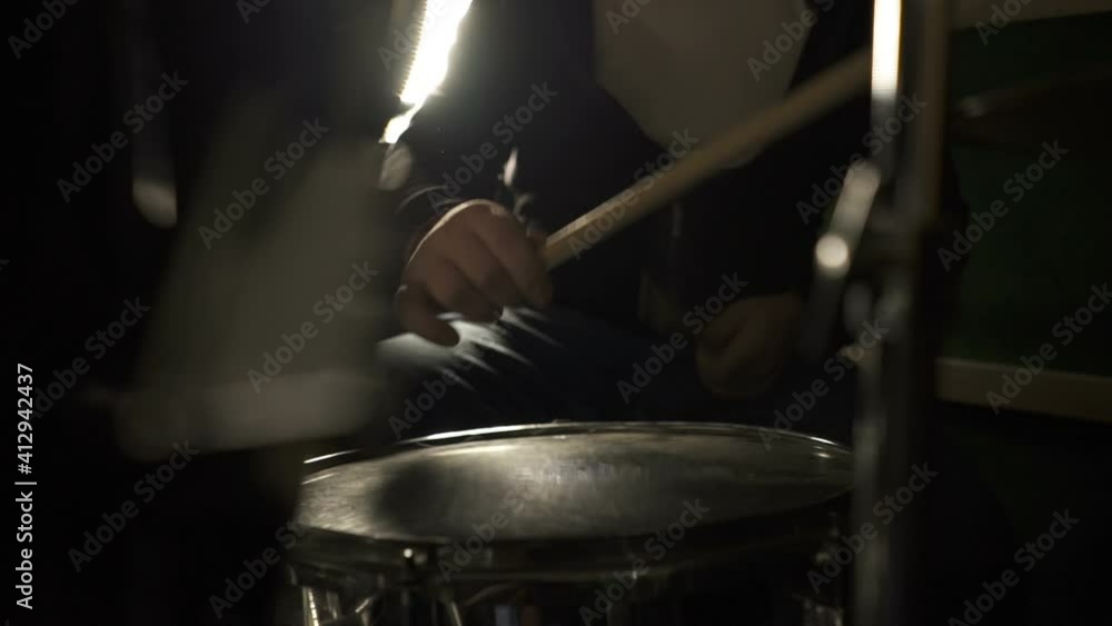 Musician is playing the drum set in the dark studio Musician is playing the drum set in the dark studio
