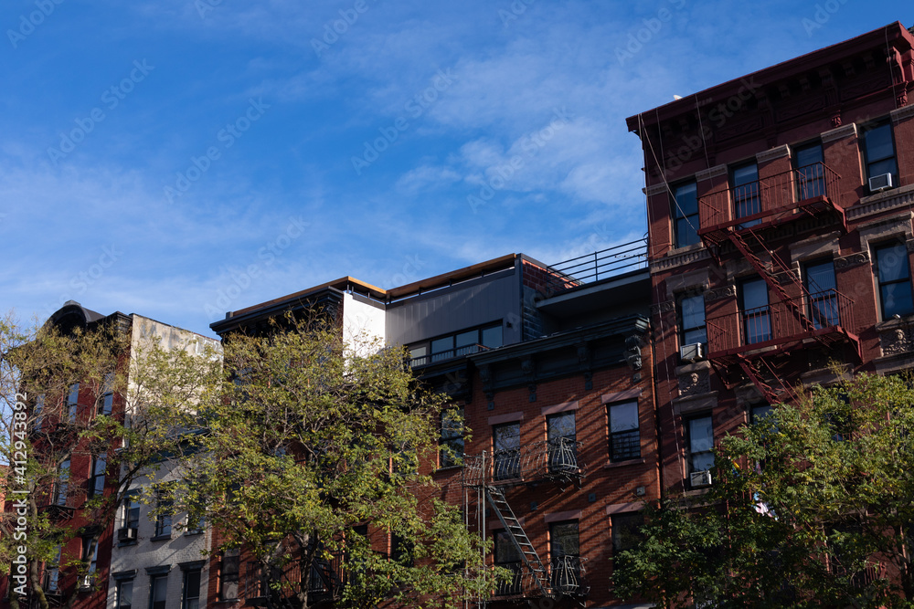 Fototapeta premium Row of Colorful Old Residential Buildings in the East Village of New York City with Fire Escapes