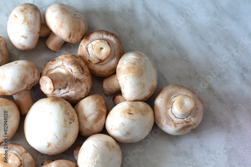 White champignons on a marble table background