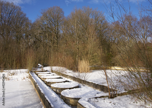 Water basins of an abandoned and decayed outdoor swimming pool in wintertime with snow © René Notenbomer