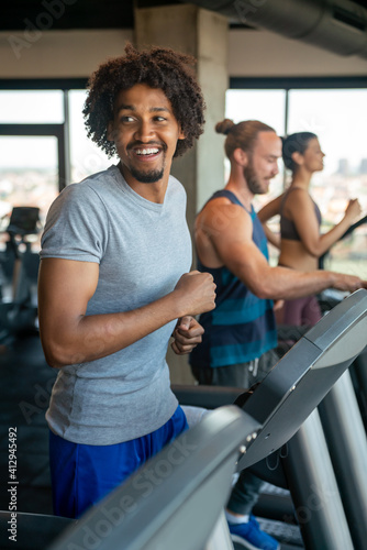 Group of young people running on treadmills in sport gym