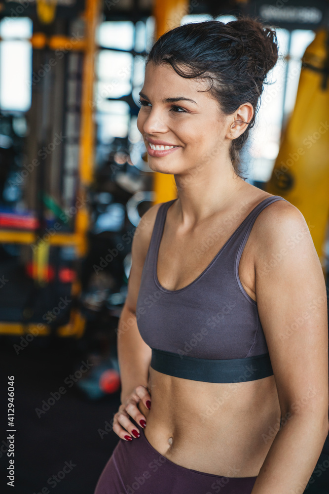 Attractive young sporty woman is working out in gym