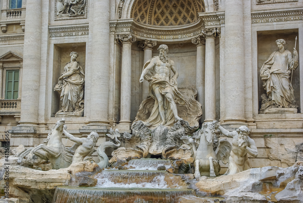Trevi fountain in Rome, Italy. Facade and a close full view towards a famous Baroque fountain. Watter, sculptures and architecture constitute the background.