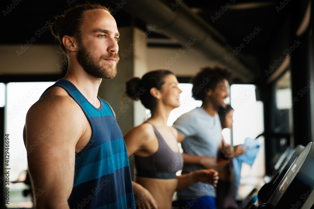 Group of young people running on treadmills in sport gym Group of young people running on treadmills in sport gym