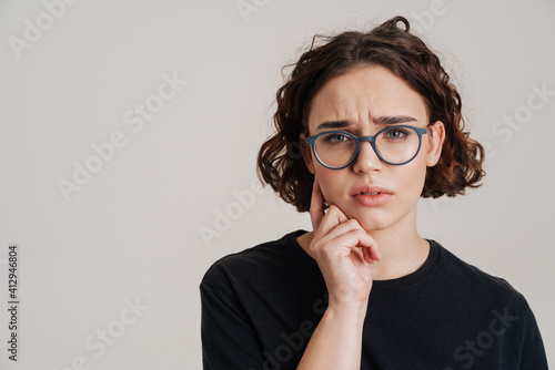Close up of a pensive young girl in casual wear isolated