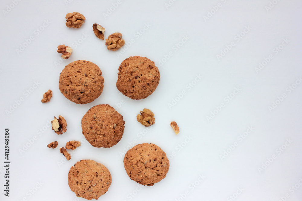 Homemade oatmeal cookies with walnuts on white table. Overhead view of oat biscuits and nuts on white background with copy space Homemade oatmeal cookies with walnuts on white table. Overhead view of oat biscuits and nuts on white background with copy space