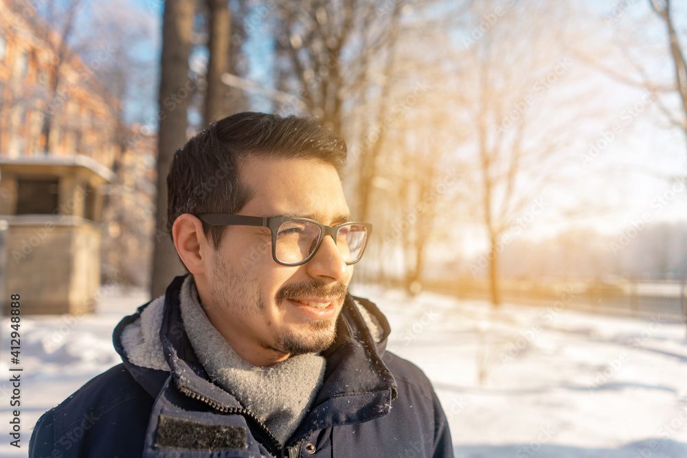 a man with glasses stands against the background of a winter landscape a man with glasses stands against the background of a winter landscape