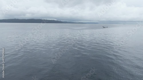 Aerial View Of Boat Splashing Water In Triton Bay In Kaimana Islands. Wide Angle Shot Of Ocean With Watercraft In Papua, Indonesia. photo