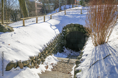Eingang zu der Spiegelgrotte auf dem Museumsberg in Flensburg im Winter mit Schnee