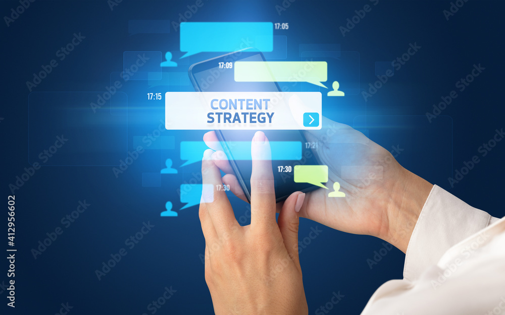 Female hand typing on smartphone with CONTENT STRATEGY inscription, social networking concept Female hand typing on smartphone with CONTENT STRATEGY inscription, social networking concept