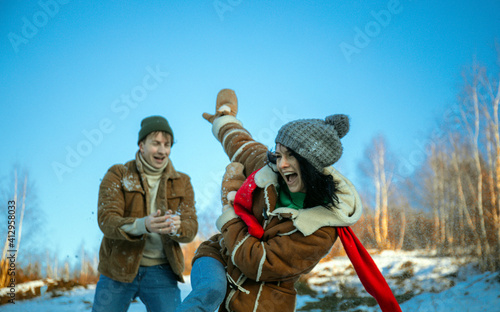 Happy couple playful together during winter holidays vacation outside in snow park 