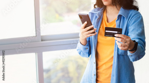 Asian woman using smartphone paying and shopping with smartphone application, online payment, banking and online shopping at the office, Digital money transfer, banking and e commerce concept.