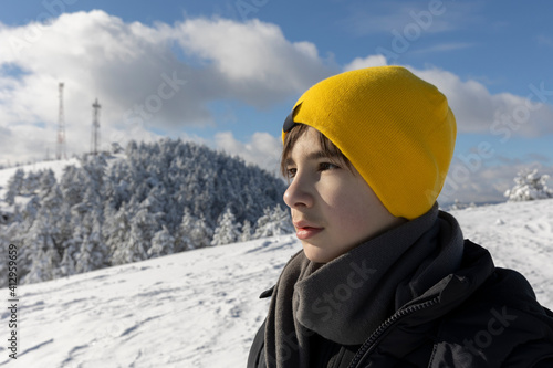 Young teenage boy walking in the mountain in the winter