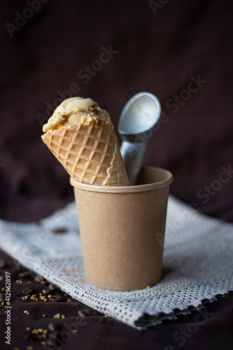 selective focus home made ice cream in waffle cone with ice cream spoon 