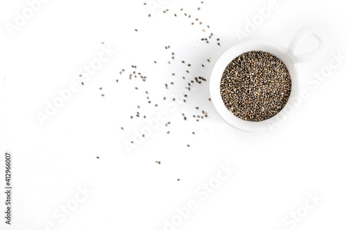 Chia seeds in a ceramic bowl on a white plate close-up.