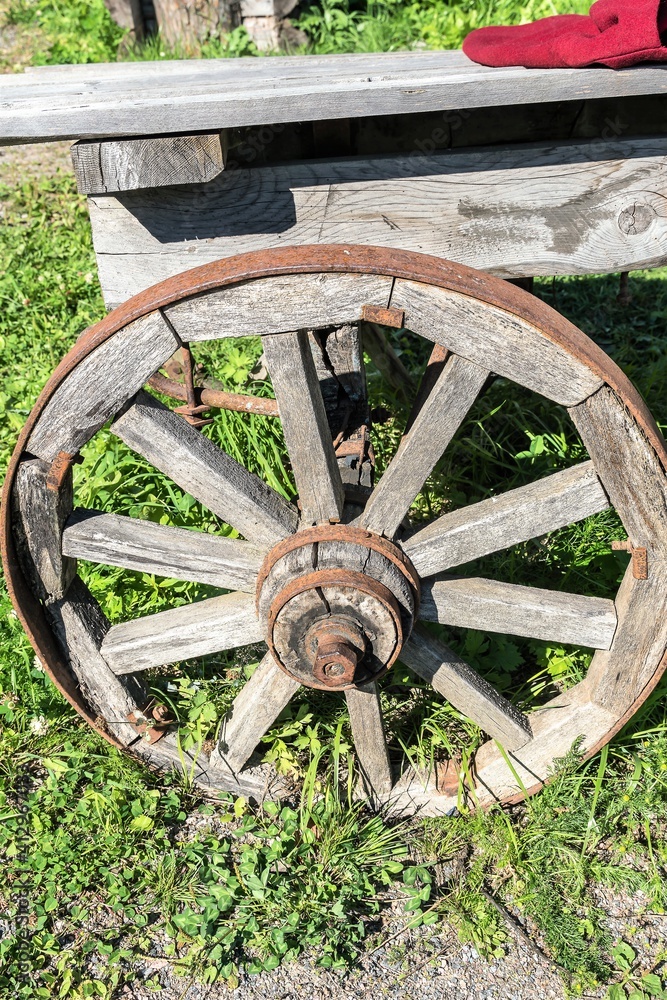 Rear wheel of an old cart in a village yard.