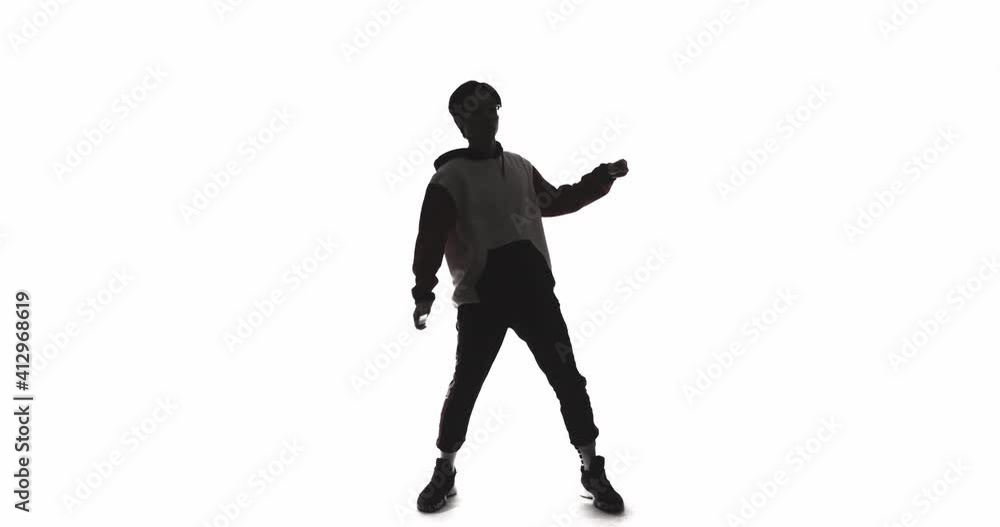 Dancer silhouette. Funky lifestyle. Hip hop culture. Modern choreography. Dark contrast outline of Asian guy performing freestyle movements isolated on white copy space background. Dancer silhouette. Funky lifestyle. Hip hop culture. Modern choreography. Dark contrast outline of Asian guy performing freestyle movements isolated on white copy space background.