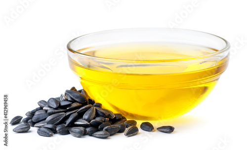 Obraz na plátne Sunflower oil in a glass bowl and sunflower seeds on a white background