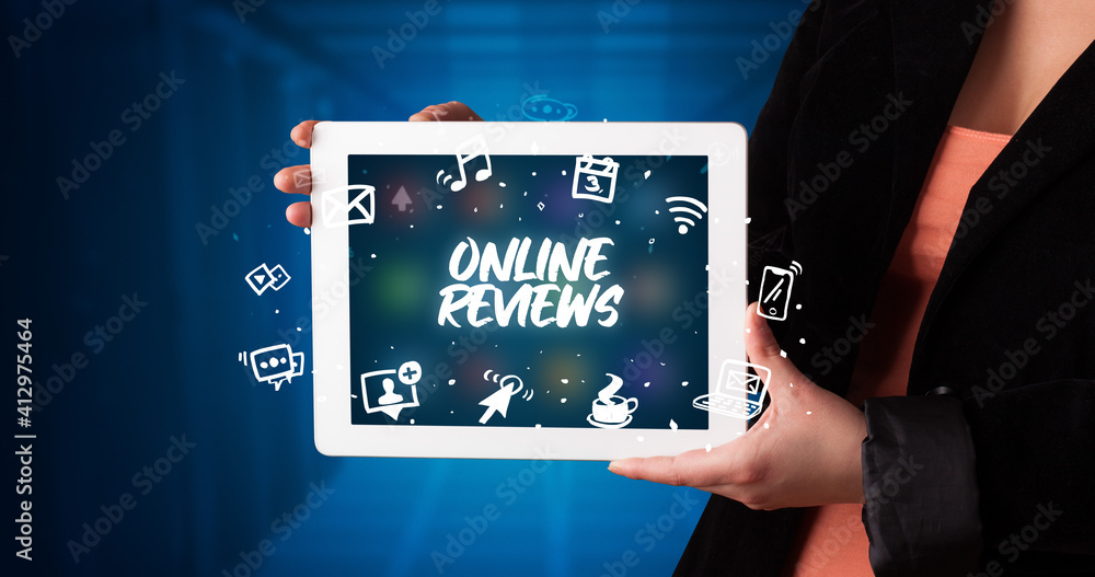 Young business person working on tablet and shows the inscription: ONLINE REVIEWS Young business person working on tablet and shows the inscription: ONLINE REVIEWS