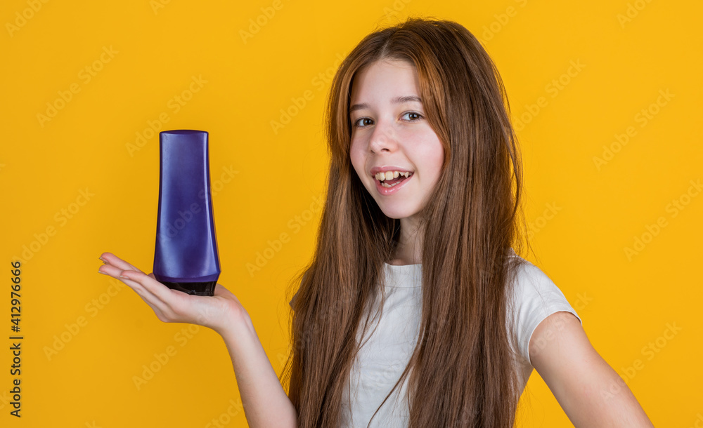 cheerful kid girl with long straight hair hold conditioner shampoo or gel bottle, bath cheerful kid girl with long straight hair hold conditioner shampoo or gel bottle, bath