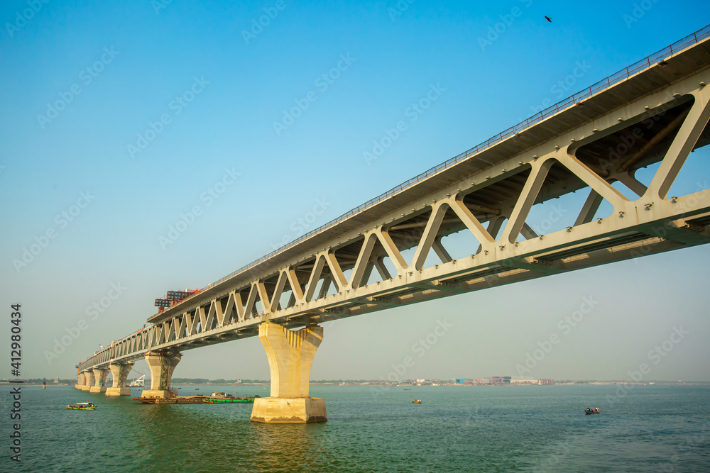 Bangladesh – February 06, 2021: A new PADMA Multipurpose Bridge is being constructed over the river Padma at Munshiganj, Dhaka, Bangladesh. Bangladesh – February 06, 2021: A new PADMA Multipurpose Bridge is being constructed over the river Padma at Munshiganj, Dhaka, Bangladesh.