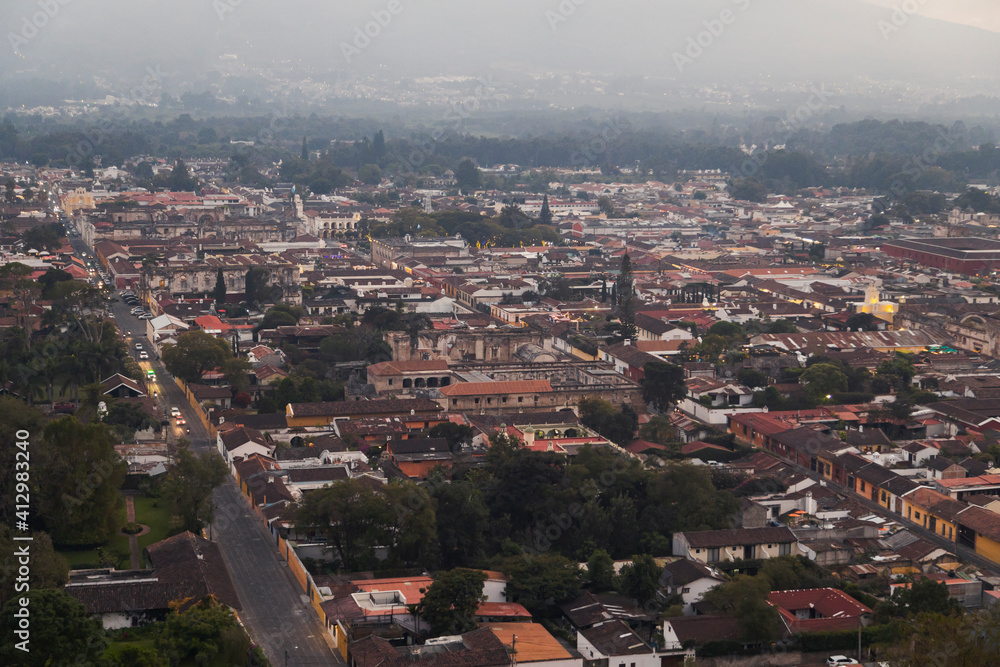 Fototapeta premium Aerial view of Antigua Guatemala colonial city at sunset on a cold day - small magical town