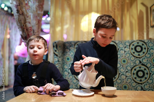 Child pouring tea in restaurant