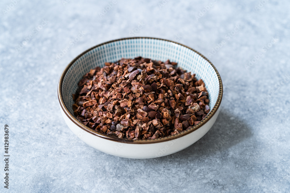 Chocolate Cacao Nibs or Cocoa Nibs in Bowl Ready to Use on Dark Wooden Surface. Chocolate Cacao Nibs or Cocoa Nibs in Bowl Ready to Use on Dark Wooden Surface.