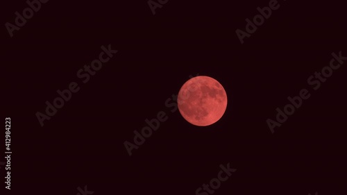 Zooming in of Red Moon in Night sky. 