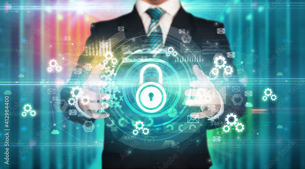 Businessman holding lock icon in his hands with multiple technology symbols around it Businessman holding lock icon in his hands with multiple technology symbols around it