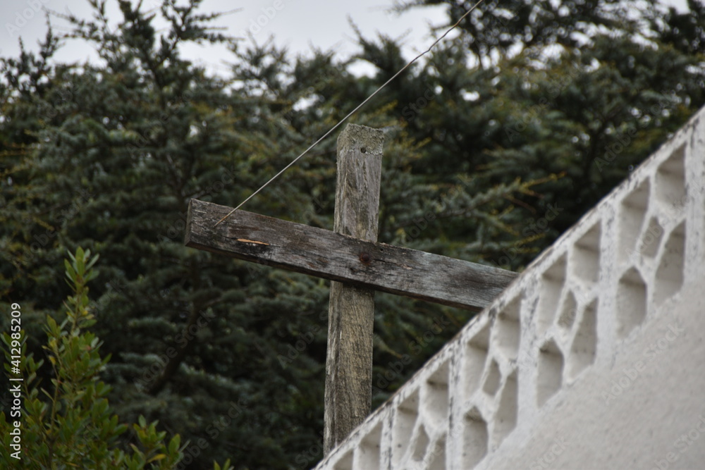 Cruz de madera con fondo de arboles.