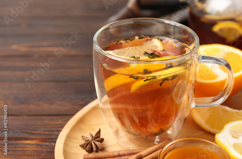 Glass cup with hot tea on wooden table, closeup